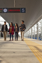 Group of young people talking on railway platform