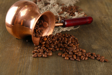 Coffee pot with coffee beans on wooden background