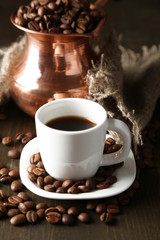 Cup of coffee and pot on wooden background