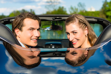 Young couple with cabriolet in summer on day trip