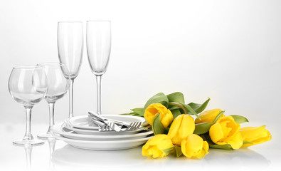 Yellow tulips and utensils for serving isolated on white