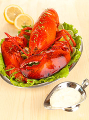 Red lobster on platter with vegetables on wooden table close-up