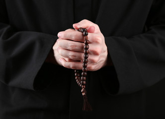 Priest holding rosary, close up