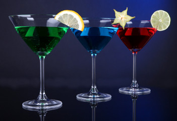 Alcoholic cocktails in martini glasses on dark blue background