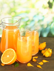 Obraz na płótnie Canvas Glasses and pitcher of orange juice