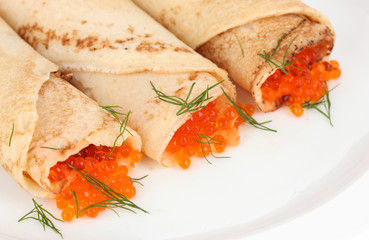 Delicious pancakes with red caviar on plate close-up