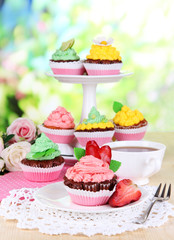 Beautiful cupcakes on dining table on natural background