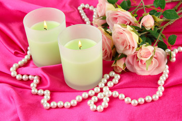 Candle on pink fabric close -up