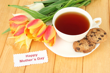 Composition of tulips and cup with some drink,