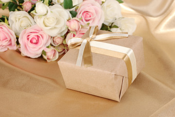 Beautiful gift on flowers background