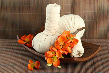 Herbal compress balls for spa treatment on bamboo background