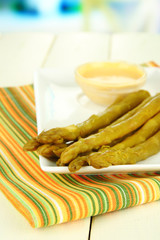 Asparagus on plate, on wooden background