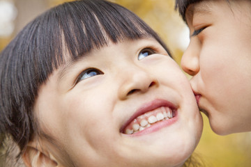 A girl kissing her older sister