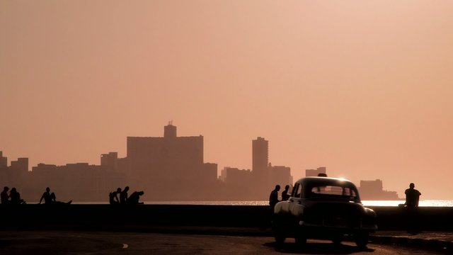 People, Caribbean sea and skyline of Havana, Cuba, at sunset