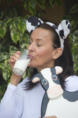 Happy relaxed mature woman drinkign milk