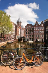 Schilderijen op glas Amsterdam city with bikes on the bridge, Holland © Tomas Marek