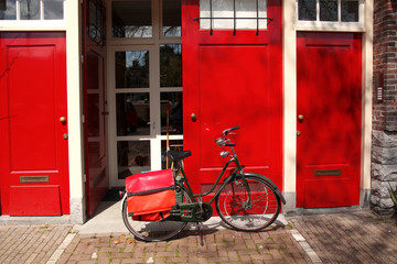 Bicycle against red house in Amsterdam, Holland