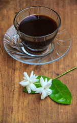 Obraz na płótnie Canvas black coffee on wooden table with Jasmine flower