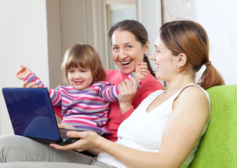 Fototapeta na wymiar Happy family of three generations with laptop