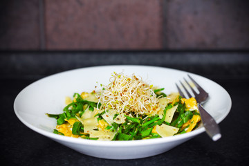 Omelette with green asparagus, shaved cheese and sprouts