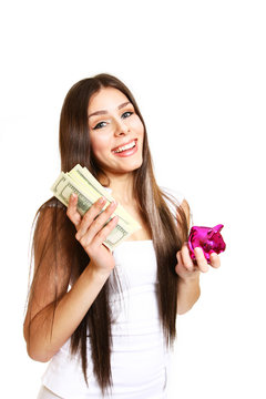 Happy young woman posing with a piggy bank and dollars on a whit