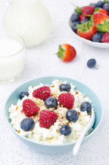 bowl of cottage cheese with berries, honey and nuts vertical