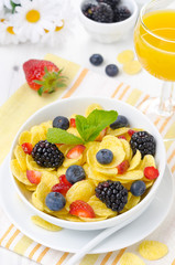 Cornflakes, fresh berries, orange juice for breakfast vertical