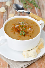 Mushroom cream soup with croutons and thyme in a bowl vertical