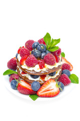 Pancake cake with whipped cream, fresh berries isolated top view