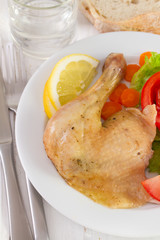chicken with salad and lemon on white plate