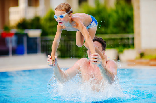young swimmer boy on swim start at swimming pool ready for jump