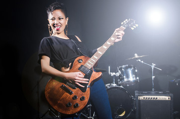 Obraz premium Woman guitar player during concert