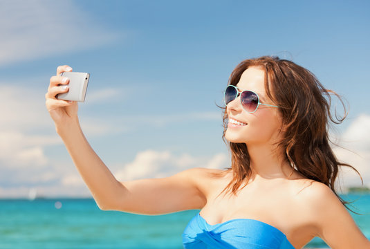 woman in bikini with phone
