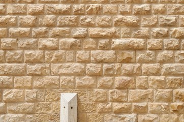 Obraz premium Texture of the wall built of rough yellow stone blocks