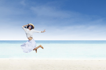 Fototapeta na wymiar Asian tourist jump at white sand beach