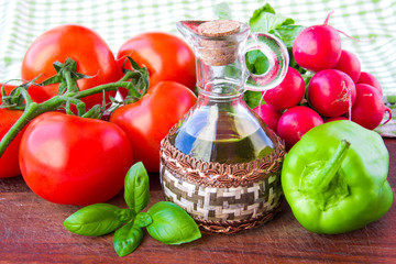 Fresh spring vegetables on the table with a bottle of oil