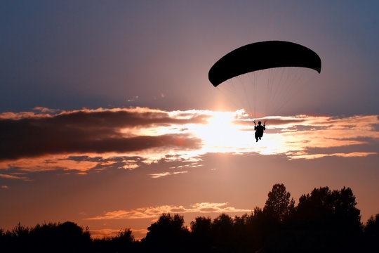 Silhouette Paraglider Pilot On Sky