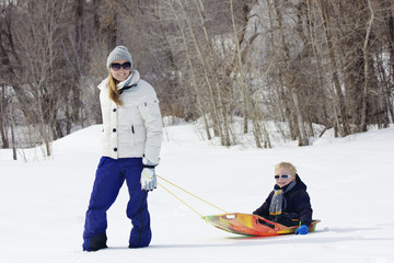 Fototapeta na wymiar Family enjoying a day Snow sledding