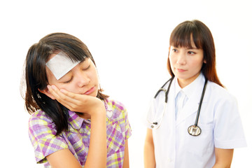 風邪の女の子を診療する女医