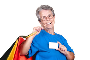 Dame âgée avec carte de crédit et sacs.