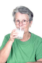 Femme âgée en train de boire un verre de lait.