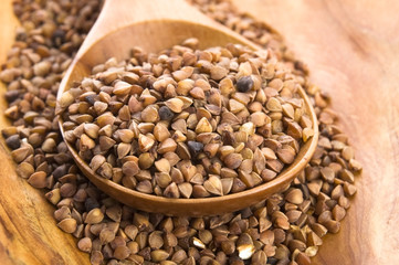 Buckwheat seeds on wooden spoon in closeup