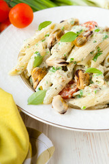 penne pasta with mussels and cream on a plate