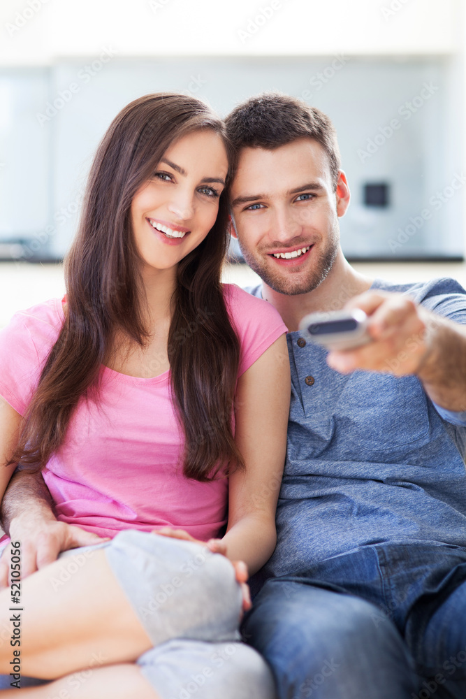 Wall mural Young couple with TV remote