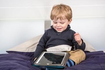 Little toddler boy playing with tablet pc