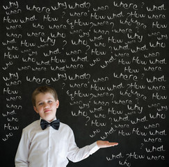 Boy businessman with chalk questions blackboard