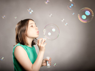 young girl blowing bubbles