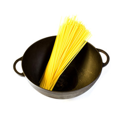 Black cast iron pot with raw pasta, isolated on a white