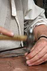 old craftsman Mason during the processing of a copper with an en