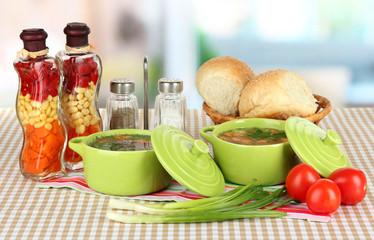 Fragrant soup in pans on table in kitchen